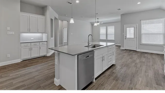 a kitchen with stainless steel appliances a sink stove refrigerator and cabinets