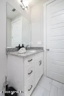 a bathroom with a granite countertop sink and a mirror