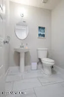 a bathroom with a toilet a sink and mirror