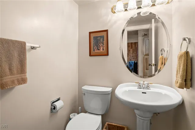 a bathroom with a sink mirror and toilet