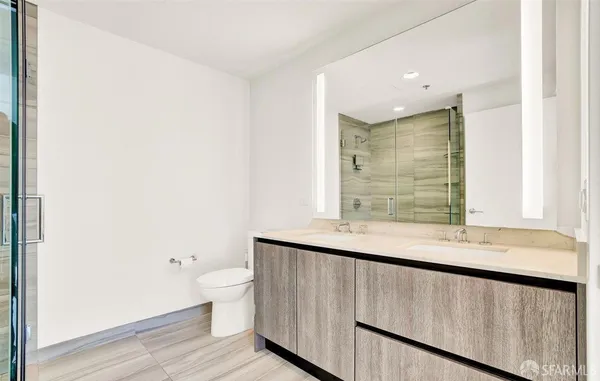a bathroom with a granite countertop sink a toilet and a large mirror