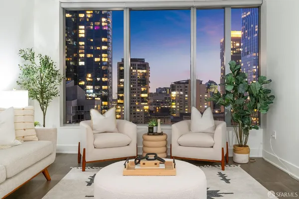 a living room with furniture a potted plant and a lamp