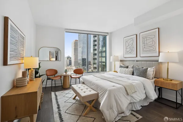 a spacious bedroom with a bed a table and chair