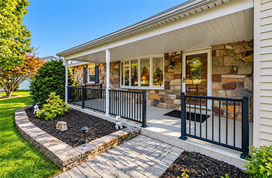 An inviting stone facade pairs beautifully with a covered front porch and neat landscaping.