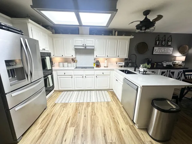 a kitchen with a sink stainless steel appliances and white cabinets