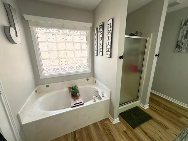 a bathroom with a tub a sink and a shower