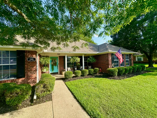 a view of a house with a yard and potted plants