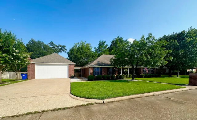 a front view of a house with a yard and trees