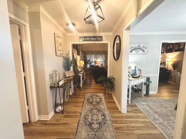 a view of a hallway with wooden floor and windows