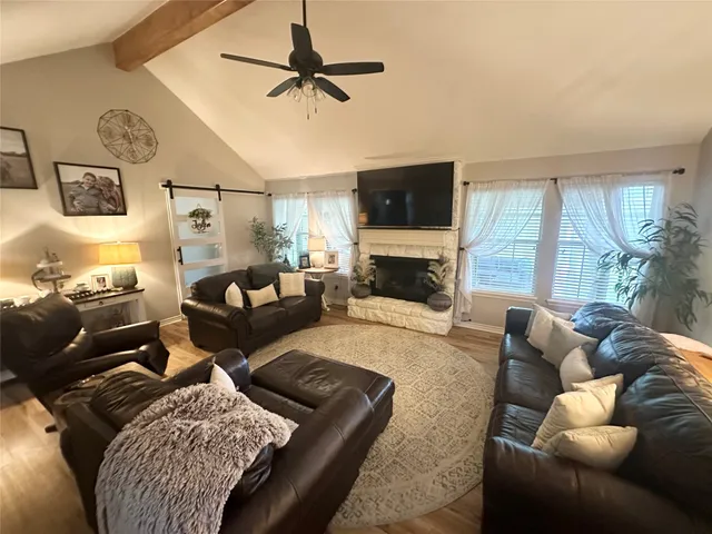 a living room with furniture a flat screen tv and a fireplace