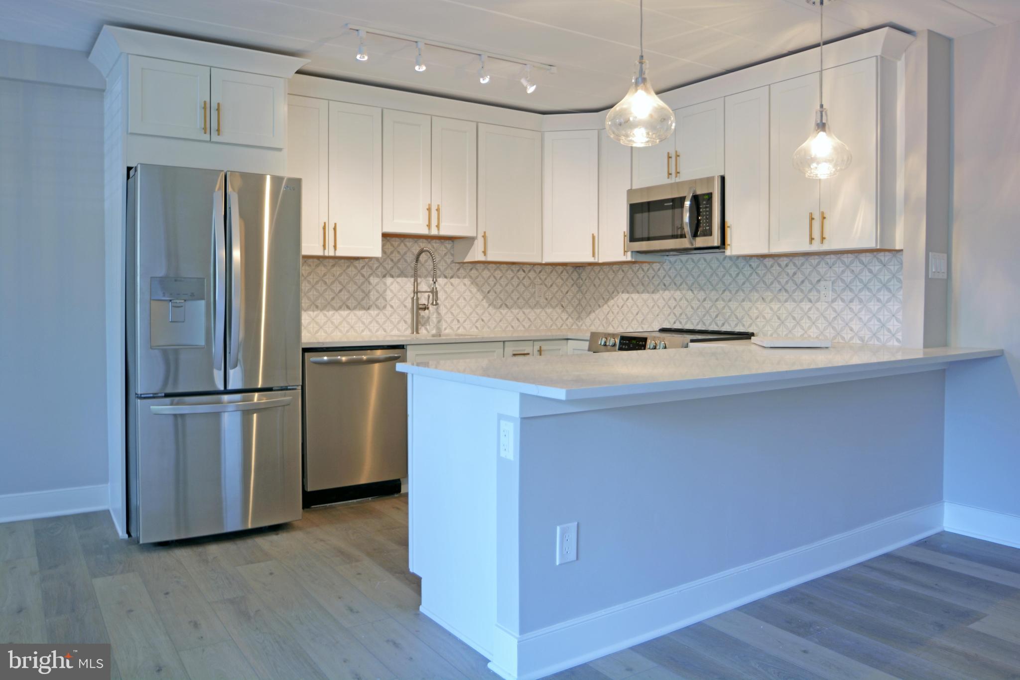 a kitchen with a refrigerator sink and cabinets