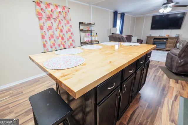 a living room with stainless steel appliances kitchen island granite countertop furniture a flat screen tv and a kitchen view
