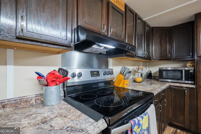 a kitchen with stainless steel appliances granite countertop a stove a sink and cabinets