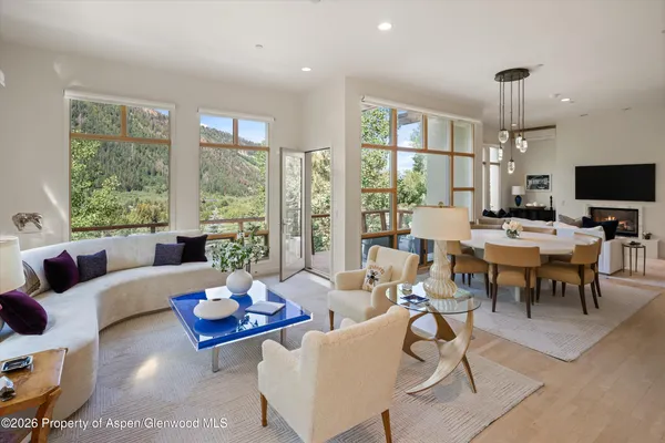 a living room with furniture large window and a table