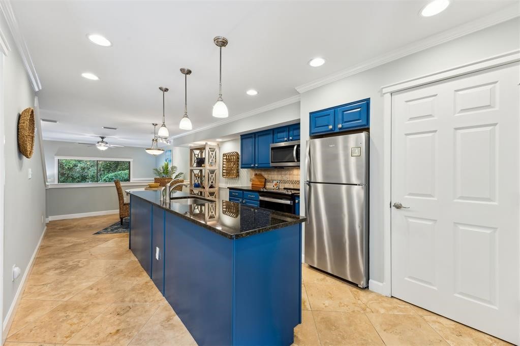 3033 Sea Marsh Road Fernandina Beach, FL 32034 - Photo 11 of 37 a kitchen with kitchen island a counter top space a sink appliances and cabinets
