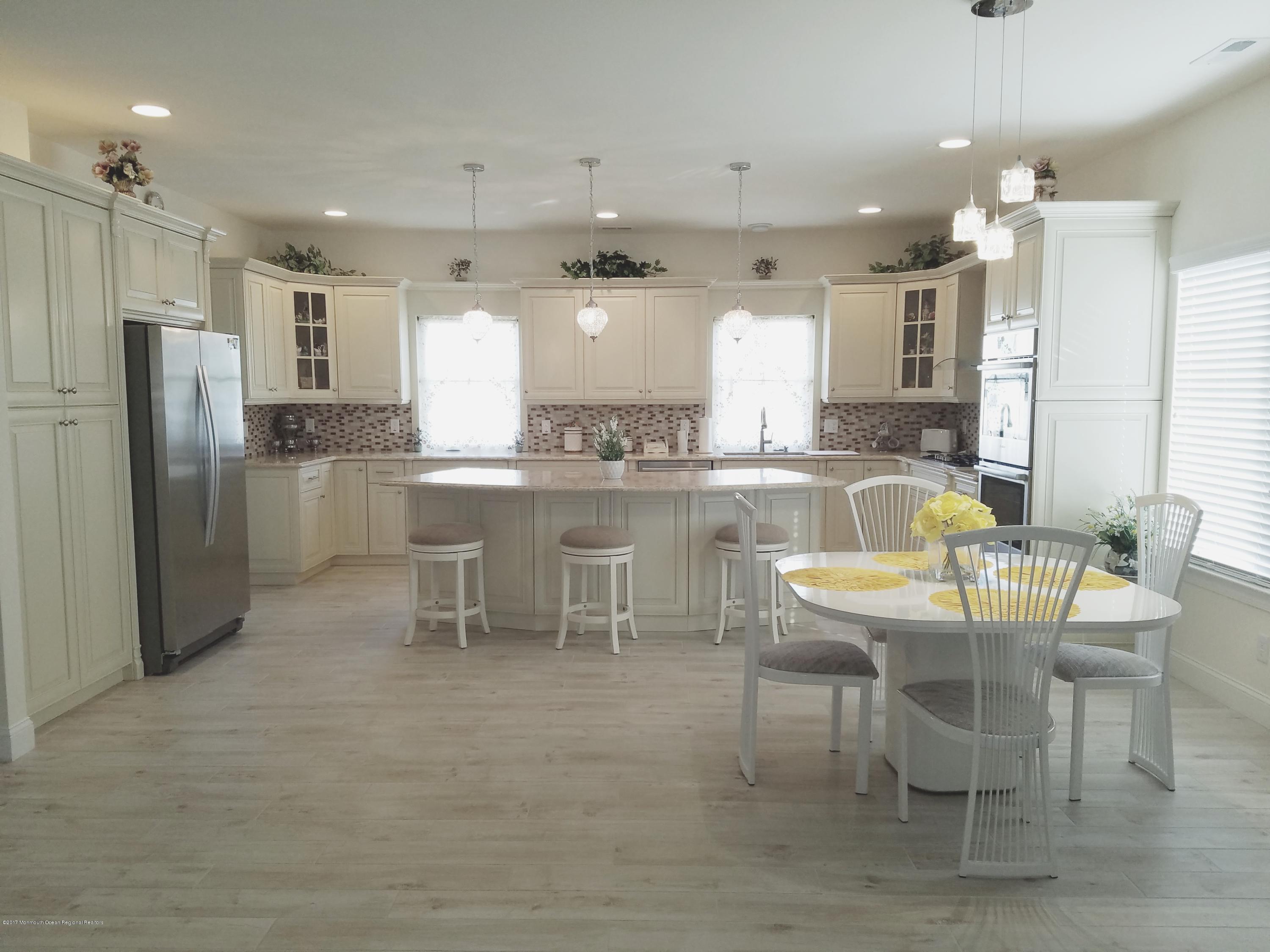 12 Cindy Court Howell, NJ 07731 - Photo 16 of 64 a dining hall with stainless steel appliances kitchen island granite countertop a table chairs and a refrigerator