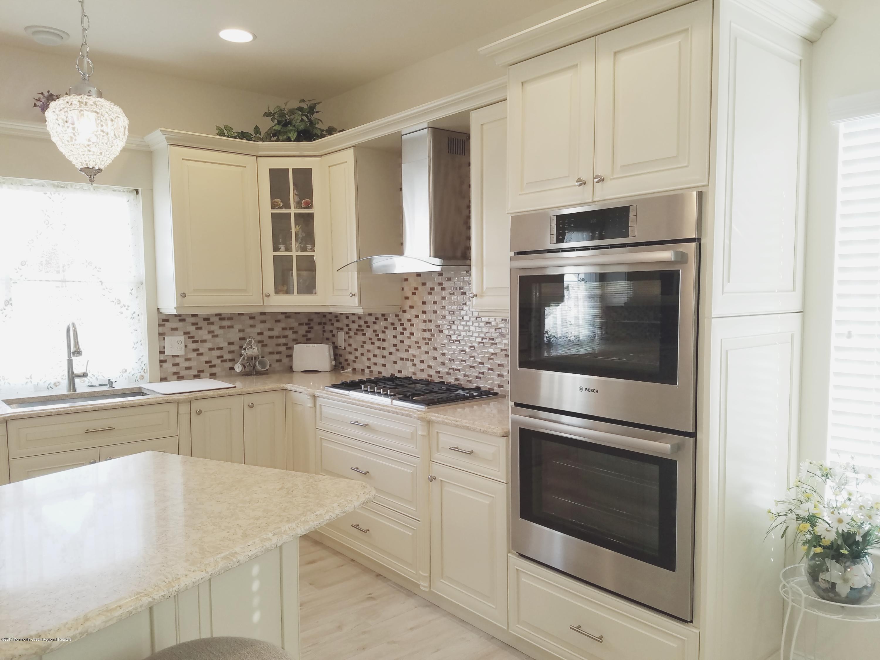 12 Cindy Court Howell, NJ 07731 - Photo 21 of 64 a kitchen with cabinets stainless steel appliances and chandelier