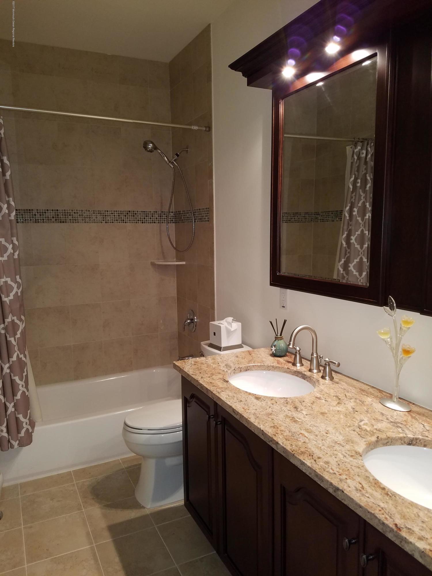 12 Cindy Court Howell, NJ 07731 - Photo 31 of 64 a bathroom with a granite countertop sink a toilet a mirror and bathtub