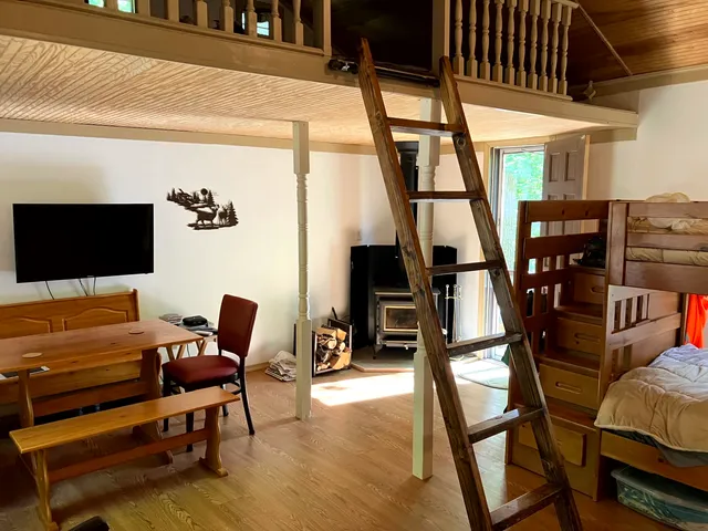 a living room with furniture a flat screen tv and floor to ceiling window