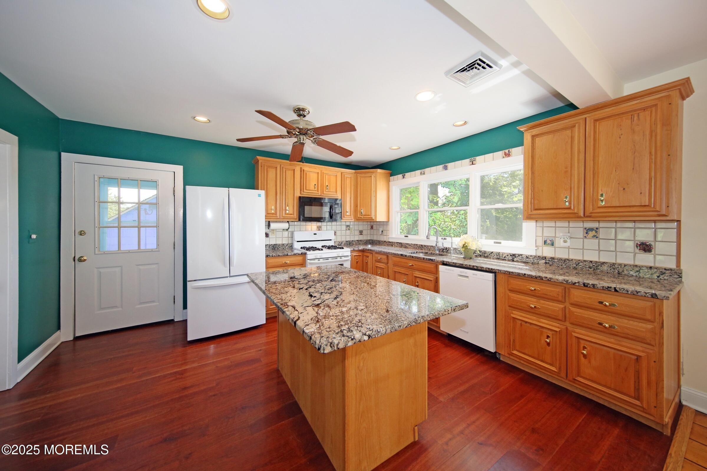 40 Riverside Avenue Oceanport, NJ 07757 - Photo 13 of 62 a kitchen with stainless steel appliances granite countertop a refrigerator a sink dishwasher a stove and white countertops with wooden floor