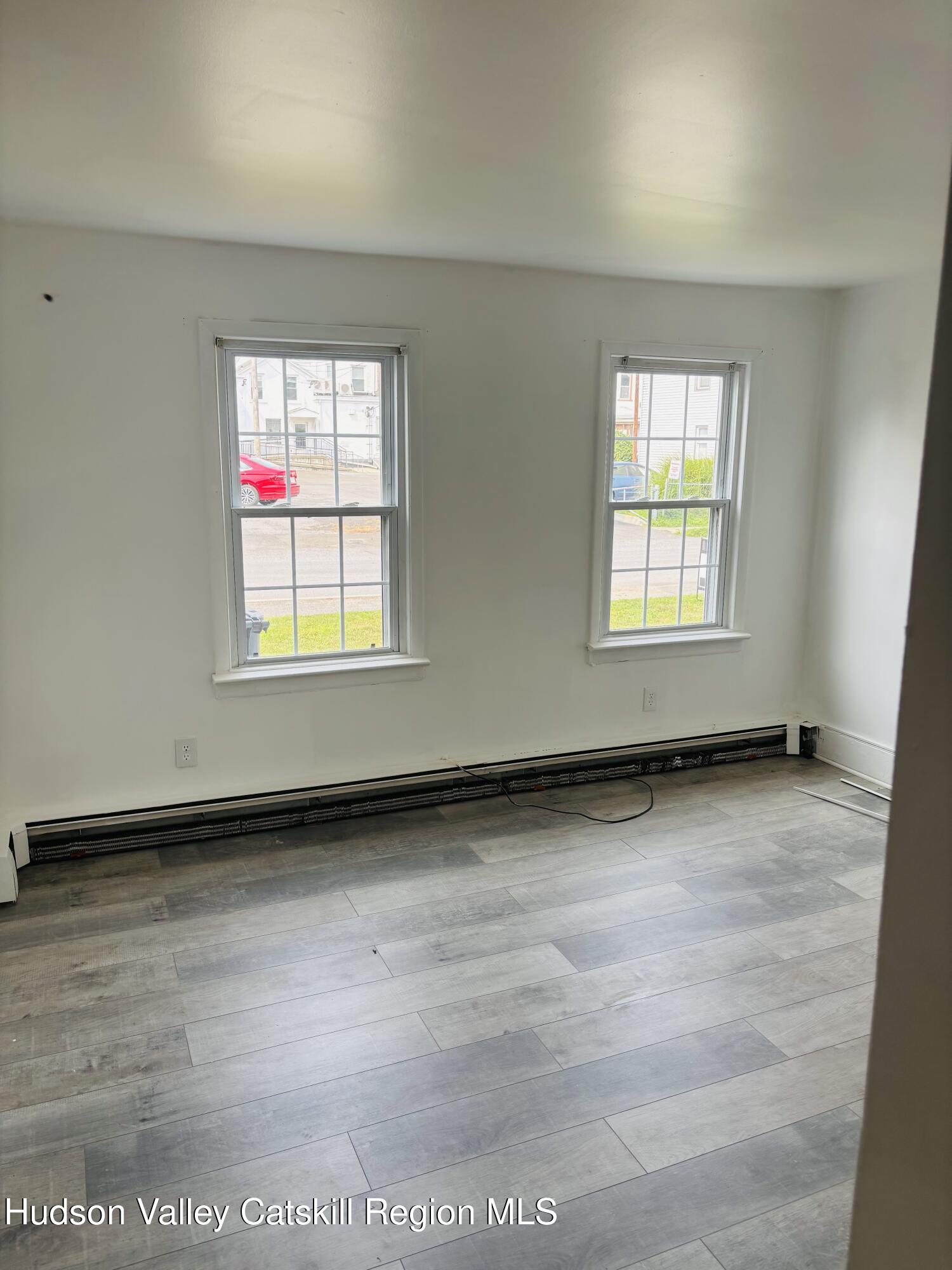 22-24 Jane Street, Unit 24A Saugerties, NY 12477 - Photo 6 of 11 an empty room with wooden floor and windows