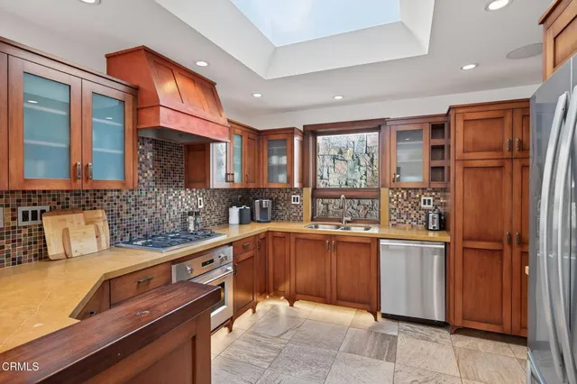 a kitchen with stainless steel appliances granite countertop a sink stove and cabinets
