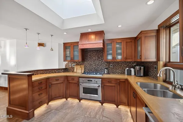 a kitchen with stainless steel appliances granite countertop a refrigerator and a stove top oven