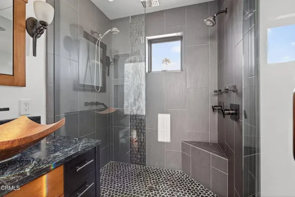 a bathroom with a granite countertop sink a toilet a mirror and shower