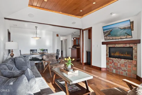 a living room with furniture two window and a dining table