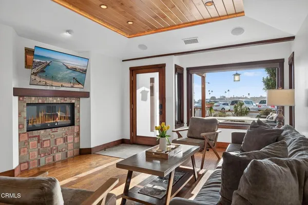 a dining room with furniture a kitchen view and wooden floor