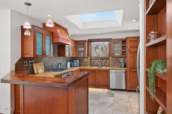 a kitchen with stainless steel appliances granite countertop a sink and a stove