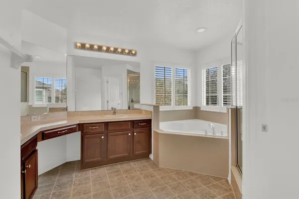 a spacious bathroom with a tub sink and mirror