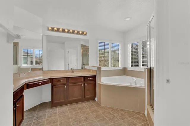 a spacious bathroom with a tub sink and mirror