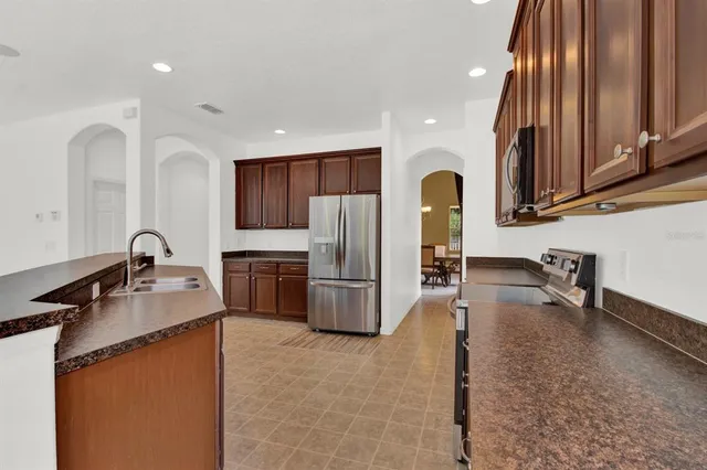 a kitchen with kitchen island granite countertop a stove and a sink with granite countertops