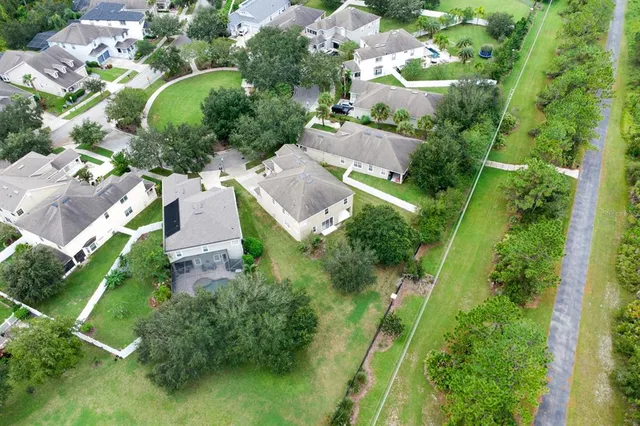 an aerial view of residential houses with outdoor space and trees