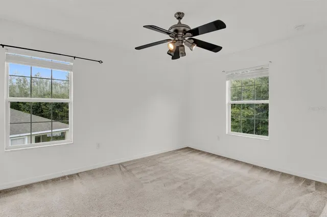 an empty room with a window and a fan