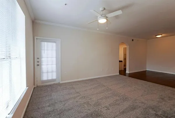 an empty room with fan and entrance