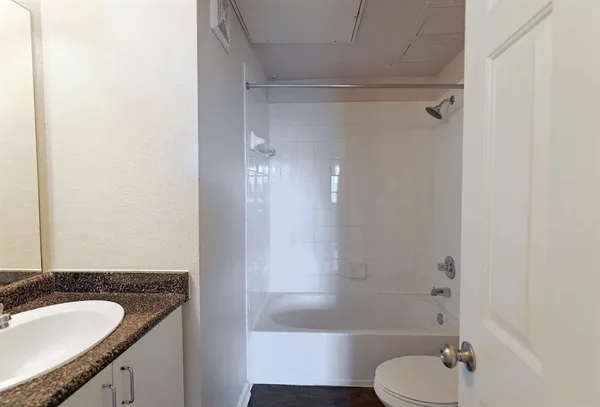 a bathroom with a granite countertop sink toilet and shower
