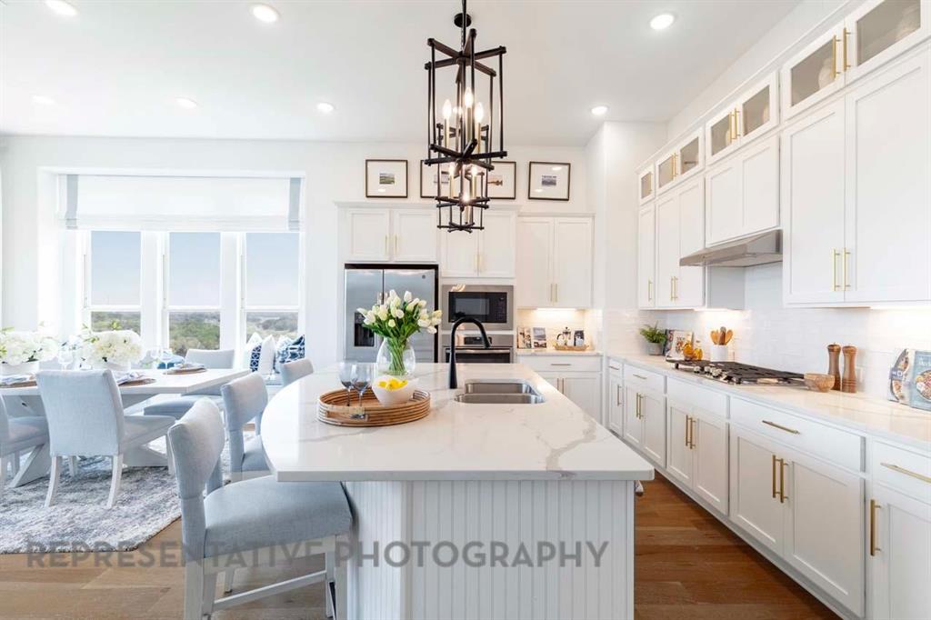 1629 Buscot Lane Haslet, TX 76052 - Photo 6 of 40 a kitchen with stainless steel appliances a dining table chairs stove and white cabinets
