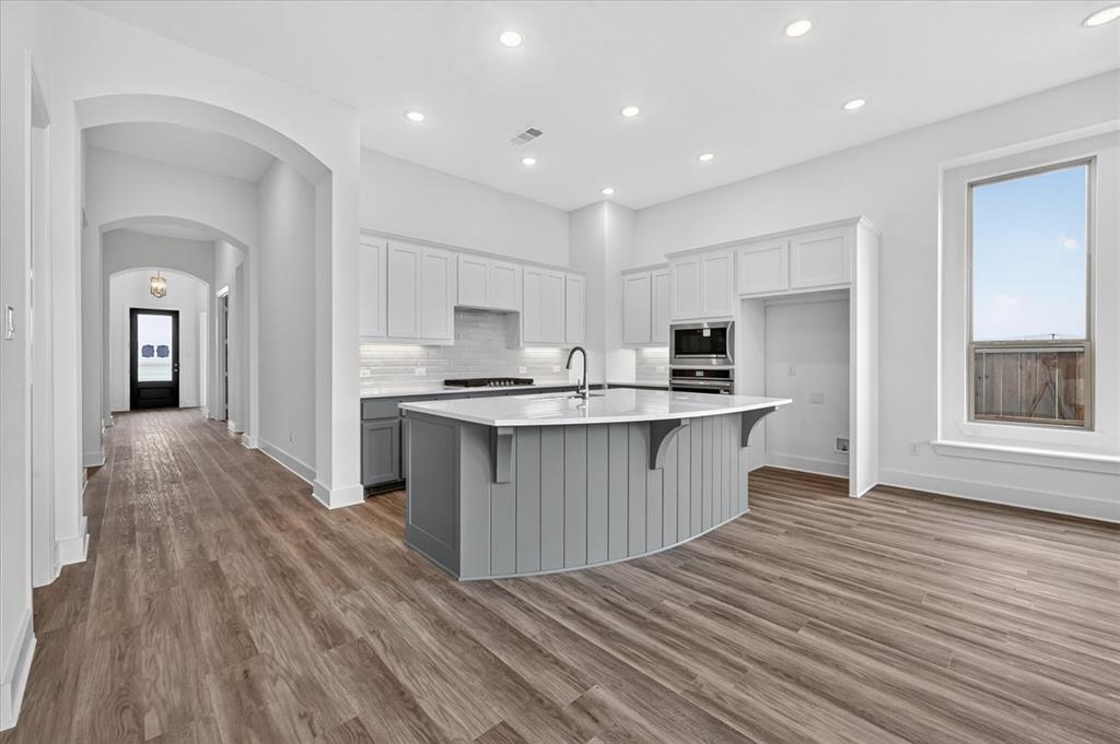 1629 Buscot Lane Fort Worth, TX 76052 - Photo 8 of 26 a large kitchen with kitchen island a sink wooden floor and a refrigerator