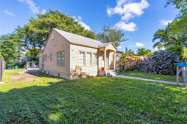 a view of a house with backyard and a tree