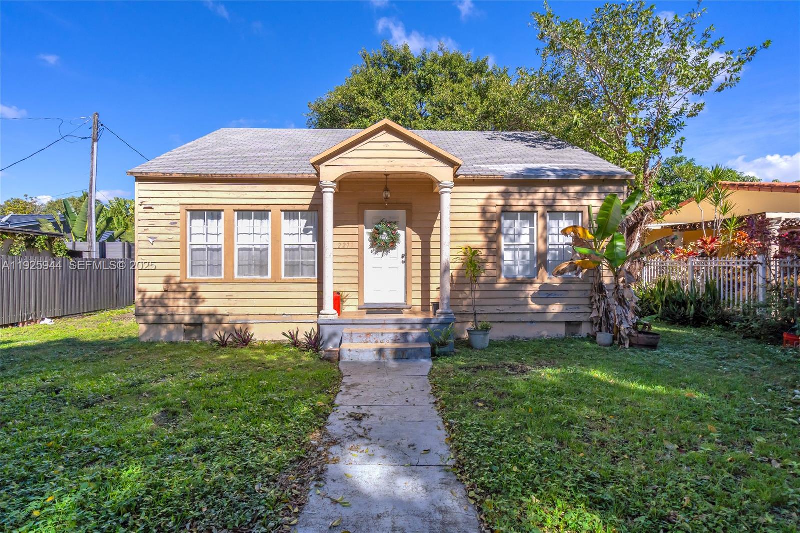 2271 Southwest 11th Street Miami, FL 33135 - Photo 2 of 17 a view of a house with a small yard and a large tree