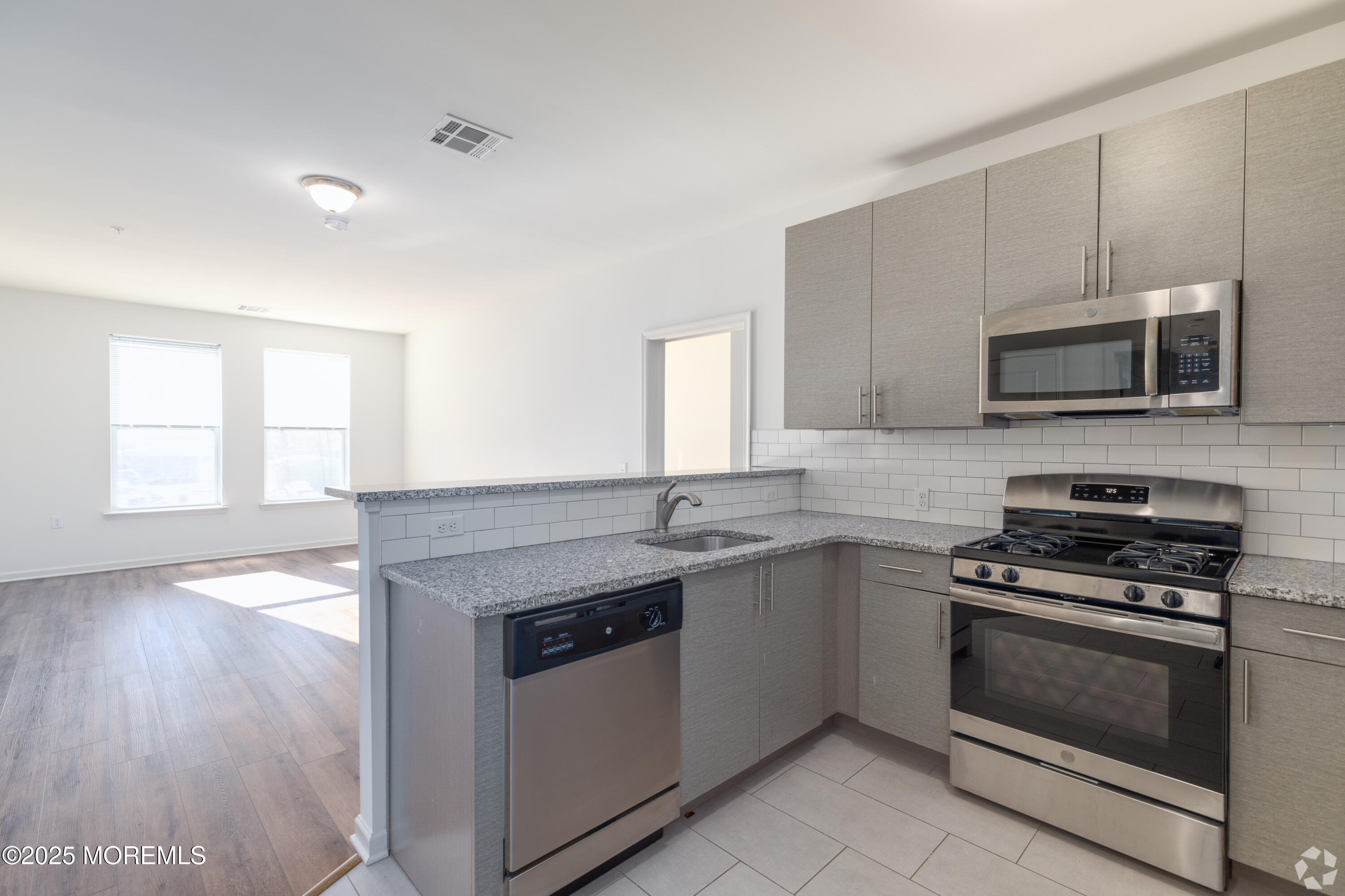 509 Memorial Drive, Unit 407 Neptune Township, NJ 07753 - Photo 2 of 8 a kitchen with sink a microwave a stove and cabinets