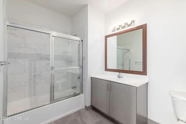 a bathroom with a shower a mirror and a sink