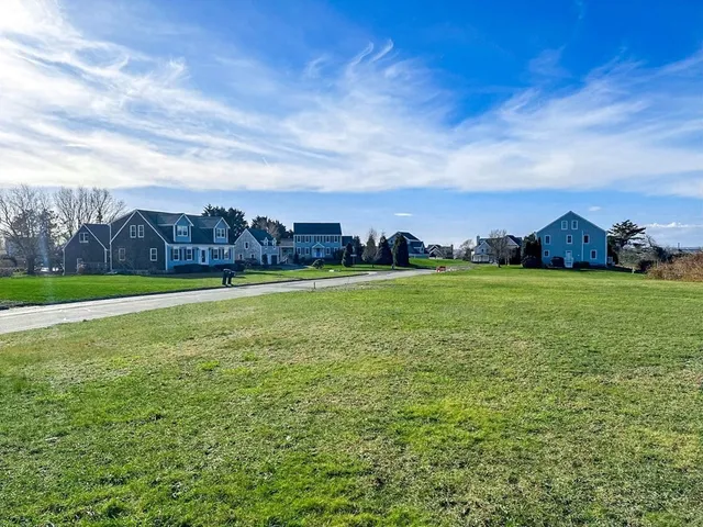 a view of a field with sitting area and a yard