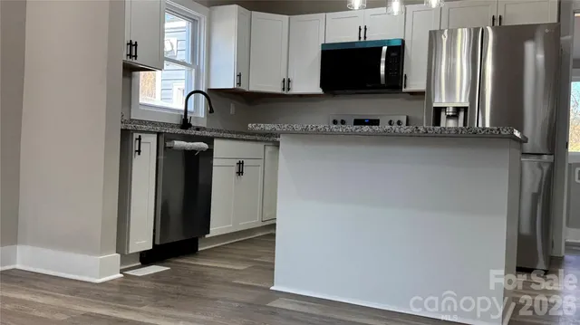 a kitchen with stainless steel appliances granite countertop a refrigerator and a stove top oven