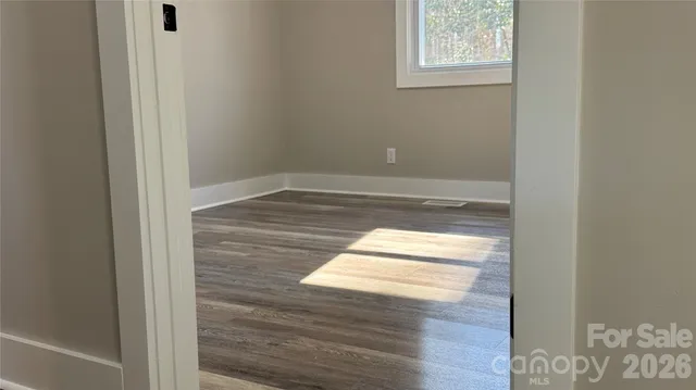 a view of empty room with wooden floor