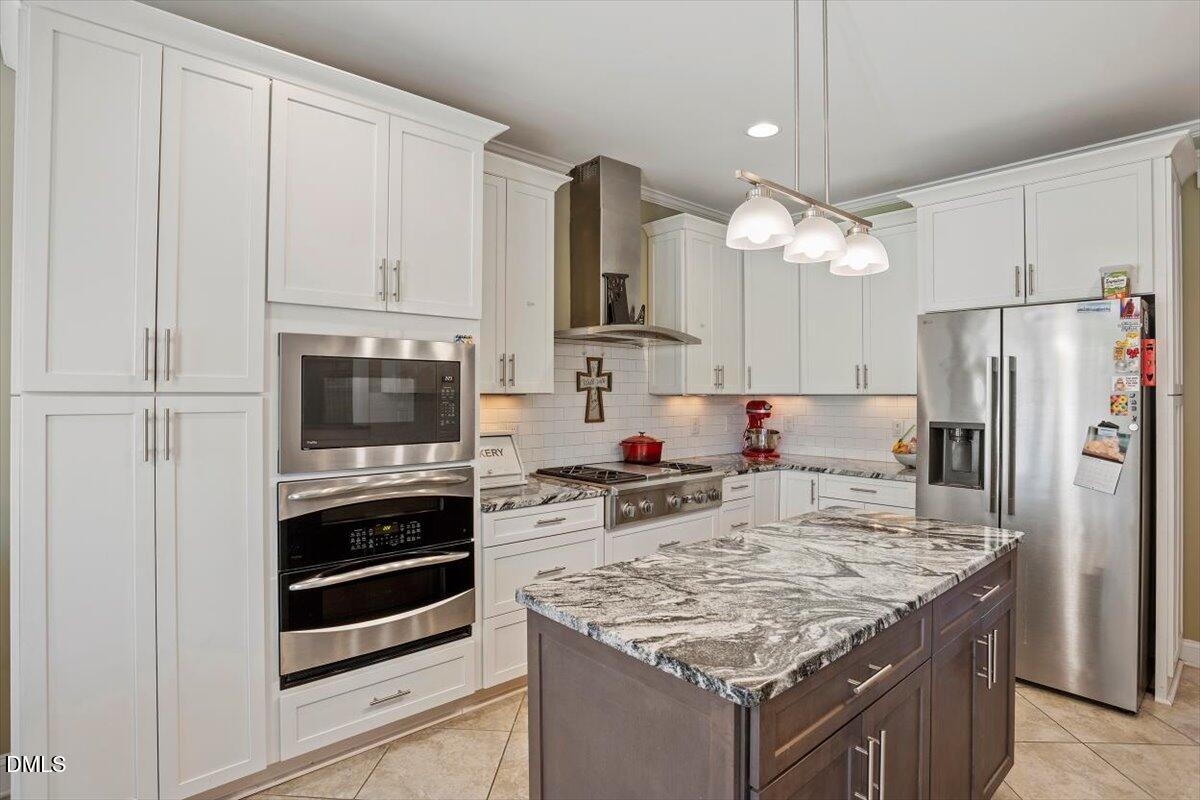 1001 Bellewood Farms Road Raleigh, NC 27603 - Photo 18 of 39 a kitchen with kitchen island a sink stove and refrigerator