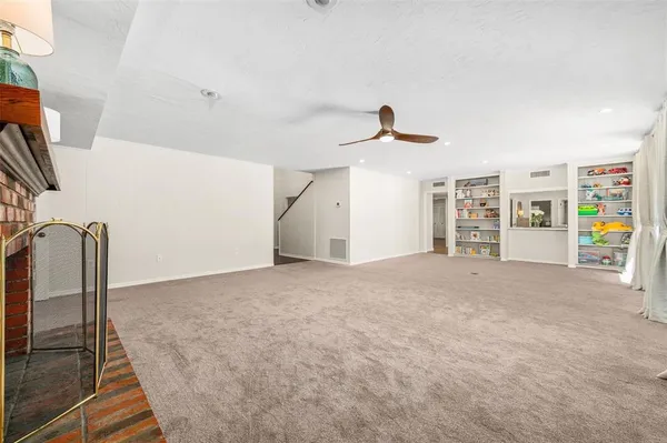 a spacious bedroom with a bed a dresser and a large window