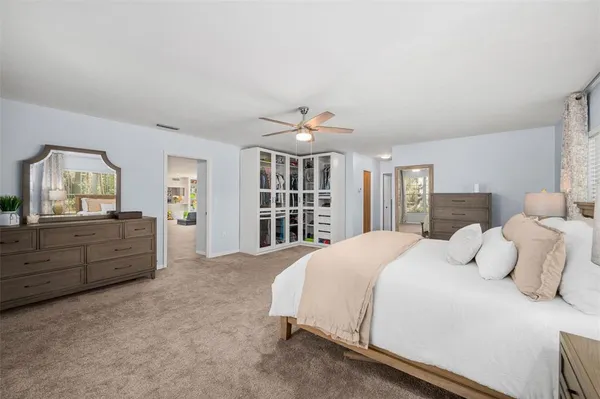 a spacious bedroom with a bed and a book shelf